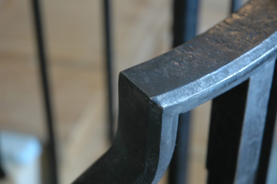 Forged Iron Handrail, Detail. Room Temperature Patina on Hot Forged Steel, with some mills scale remaining. The patina helps to blend areas where some welding has occured to give it a more seamless appearance. Wax is the top coat. 